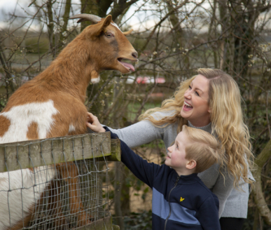Mum and son feeding a goat at barleylands