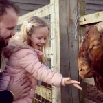 Girl and father at barleylands feeding a goat