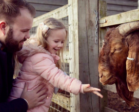 Girl and father at barleylands feeding a goat