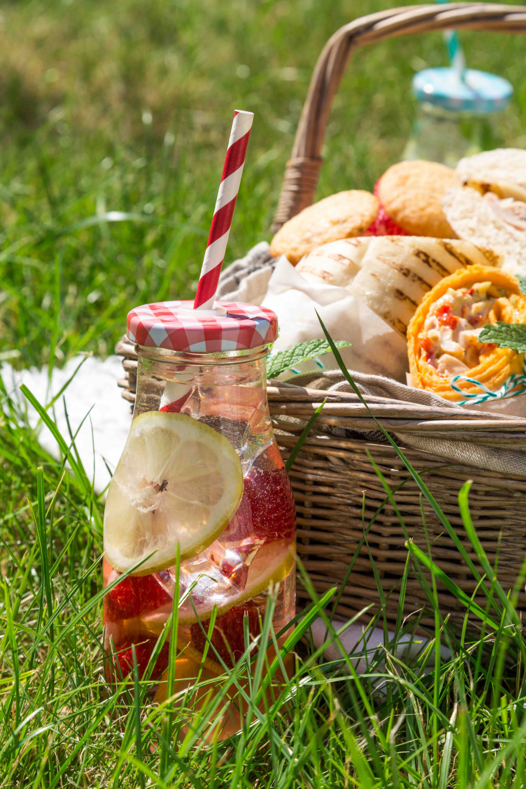 Picnic basket with food on green sunny lawn Barleylands